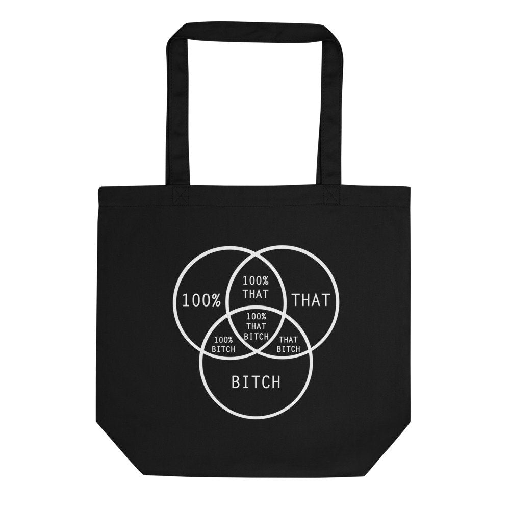 Black tote bag that has a venn diagram reading 100% That Bitch in white text, on a white background 