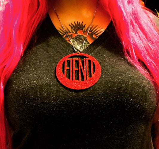 Large round laser cut red glitter acrylic pendant that reads the word FIEND laser cut into the center.